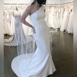 One-Shoulder White Wedding Dress with Bow Accent and Matching Veil